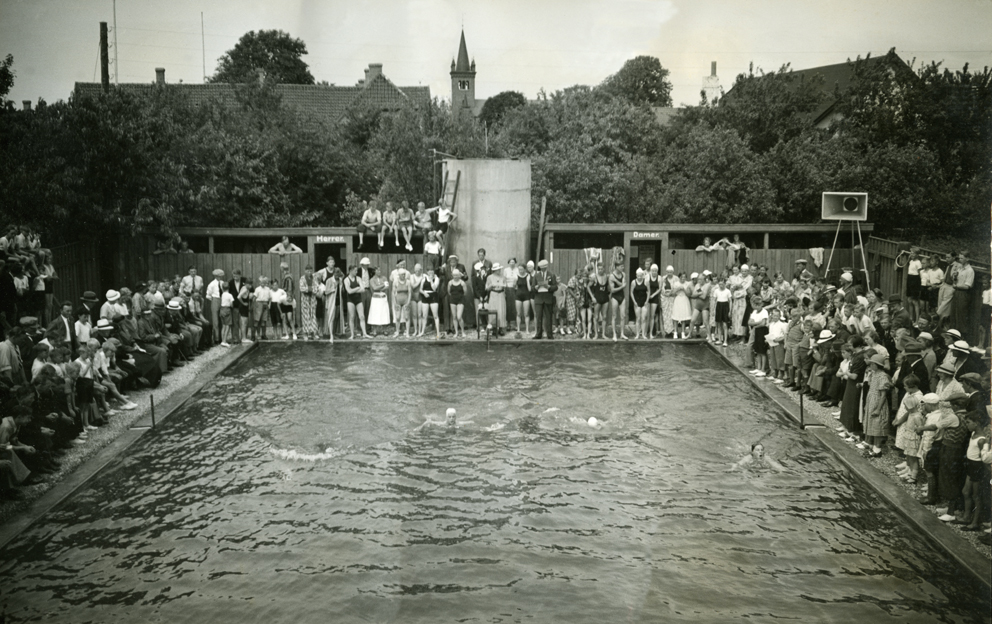 Ugerløse Friluftsbad ved indvielsen den 20. august 1933 Flere end 2.500 mennesker var mødt op til indvielsen, så svømmeopvisningen måtte vises over flere omgange, da der ikke var plads til alle omkring bassinnet.